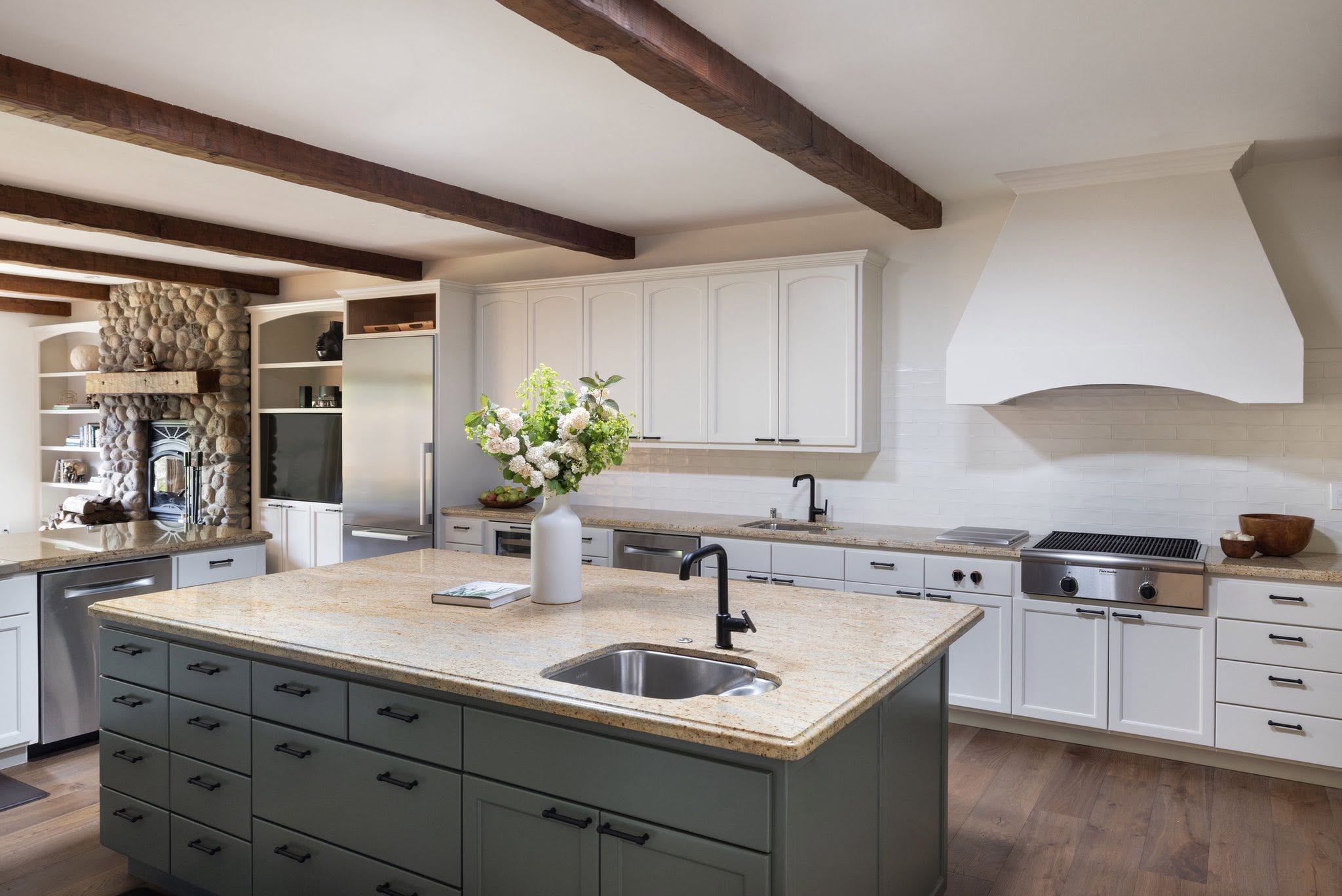 Kitchen island with wood beams and stone fireplace